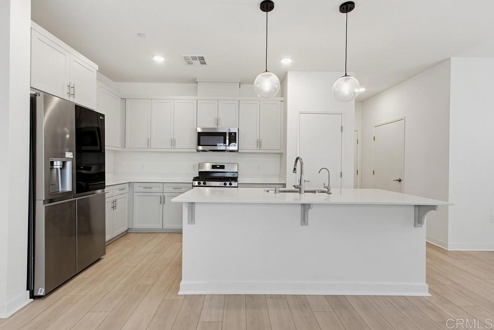 35131 Rangpur Lane Fallbrook, CA 92028 - Photo 28 of 61 a kitchen with stainless steel appliances kitchen island a white cabinets and refrigerator