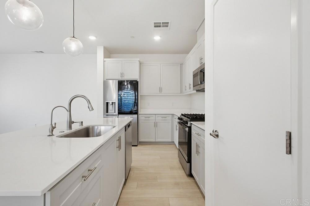 35131 Rangpur Lane Fallbrook, CA 92028 - Photo 31 of 61 a kitchen with white cabinets a sink and stainless steel appliances