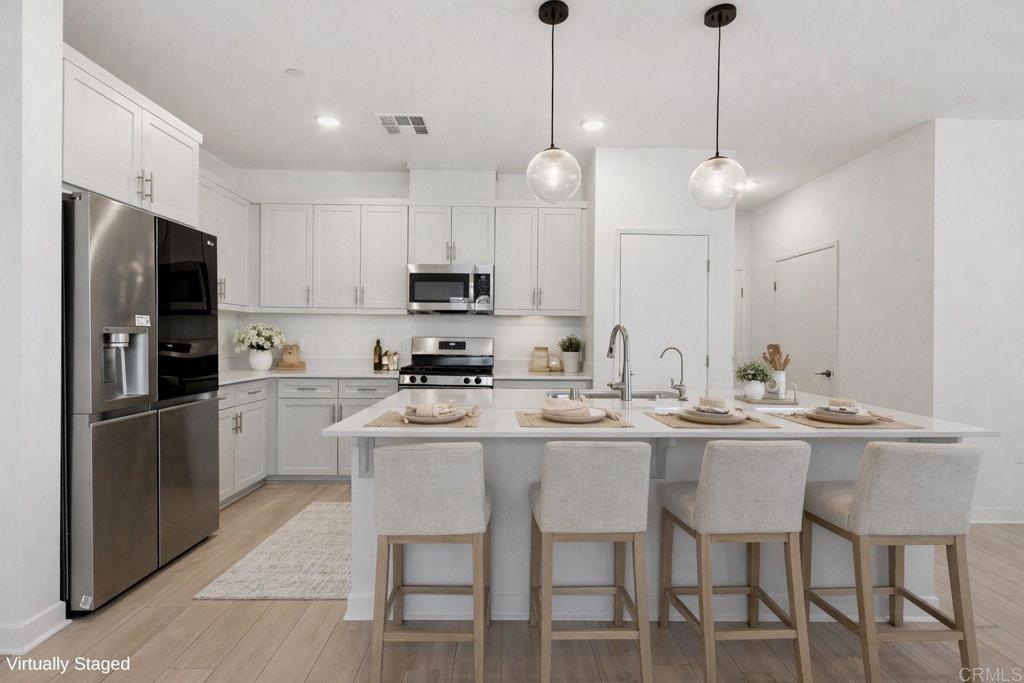 35131 Rangpur Lane Fallbrook, CA 92028 - Photo 10 of 61 a kitchen with kitchen island white cabinets and stainless steel appliances