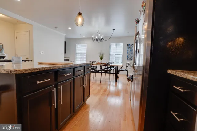 a living room with furniture and kitchen view with wooden floor