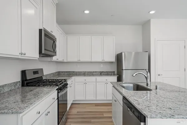 a kitchen with granite countertop a sink and a stove top oven