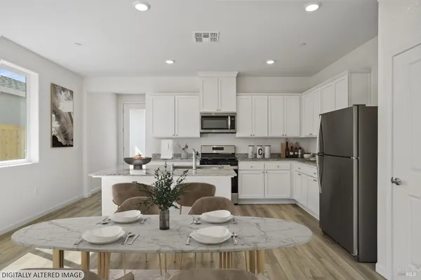 a kitchen with a refrigerator and a stove top oven