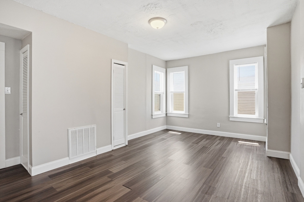 196 Irving Street Fall River, MA 02723 - Photo 12 of 34 an empty room with wooden floor and windows