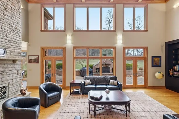 a living room with fireplace furniture and floor to ceiling windows