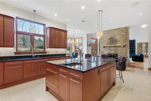 a kitchen with stainless steel appliances granite countertop a sink a stove and a wooden cabinets