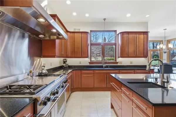 a kitchen with stainless steel appliances granite countertop a kitchen island hardwood floor and a sink