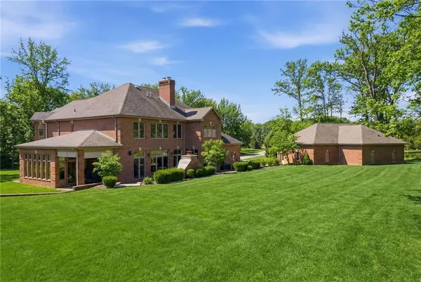 a front view of a house with a yard and green space
