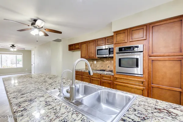 a kitchen with stainless steel appliances granite countertop a sink and cabinets