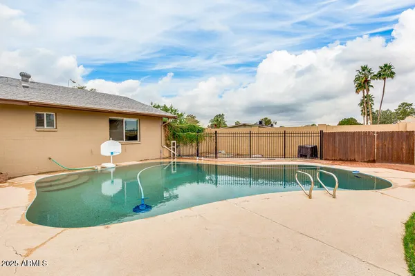 a view of a backyard with swimming pool