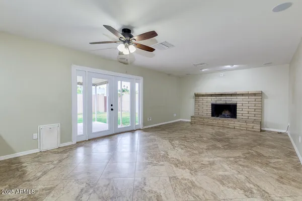 a view of an empty room with a fireplace and a window
