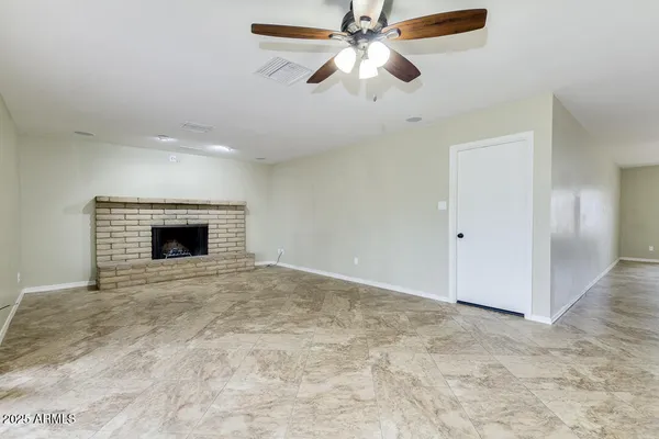 an empty room with fan and windows