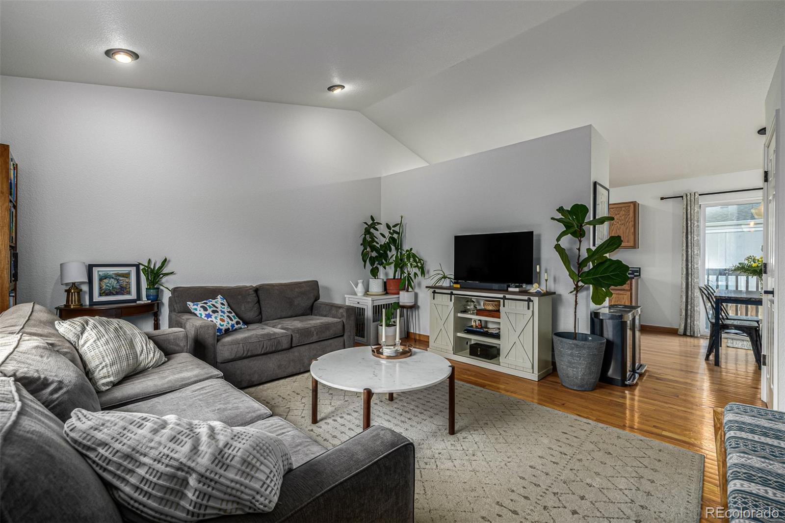 965 Wolff Street, Unit D Denver, CO 80204 - Photo 2 of 29 a living room with furniture a flat screen tv and a potted plant