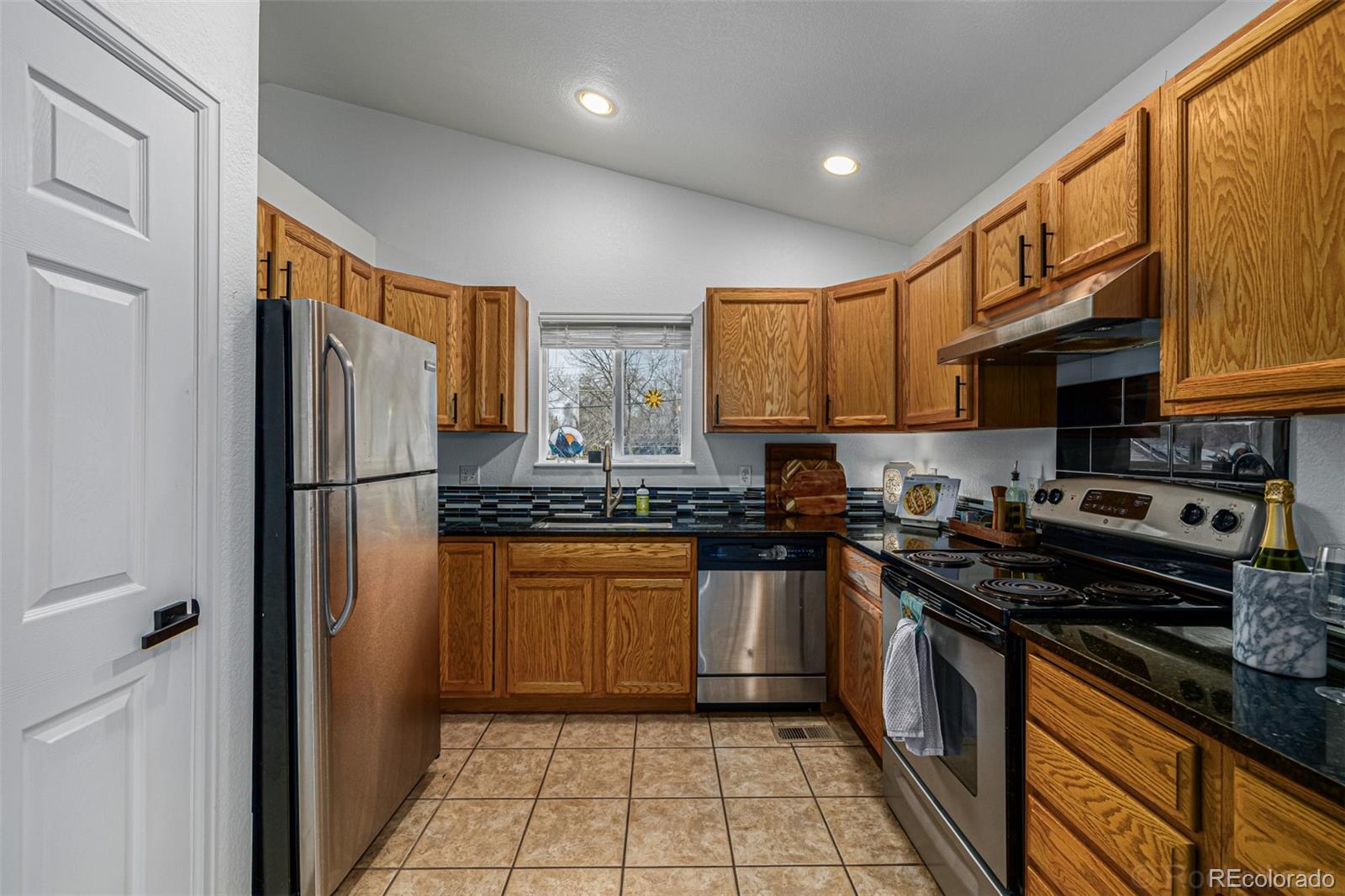 965 Wolff Street, Unit D Denver, CO 80204 - Photo 6 of 29 a kitchen with stainless steel appliances granite countertop a refrigerator stove and sink