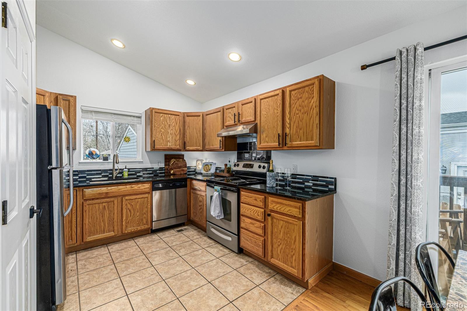 965 Wolff Street, Unit D Denver, CO 80204 - Photo 7 of 29 a kitchen with stainless steel appliances granite countertop a stove top oven a sink dishwasher and a refrigerator