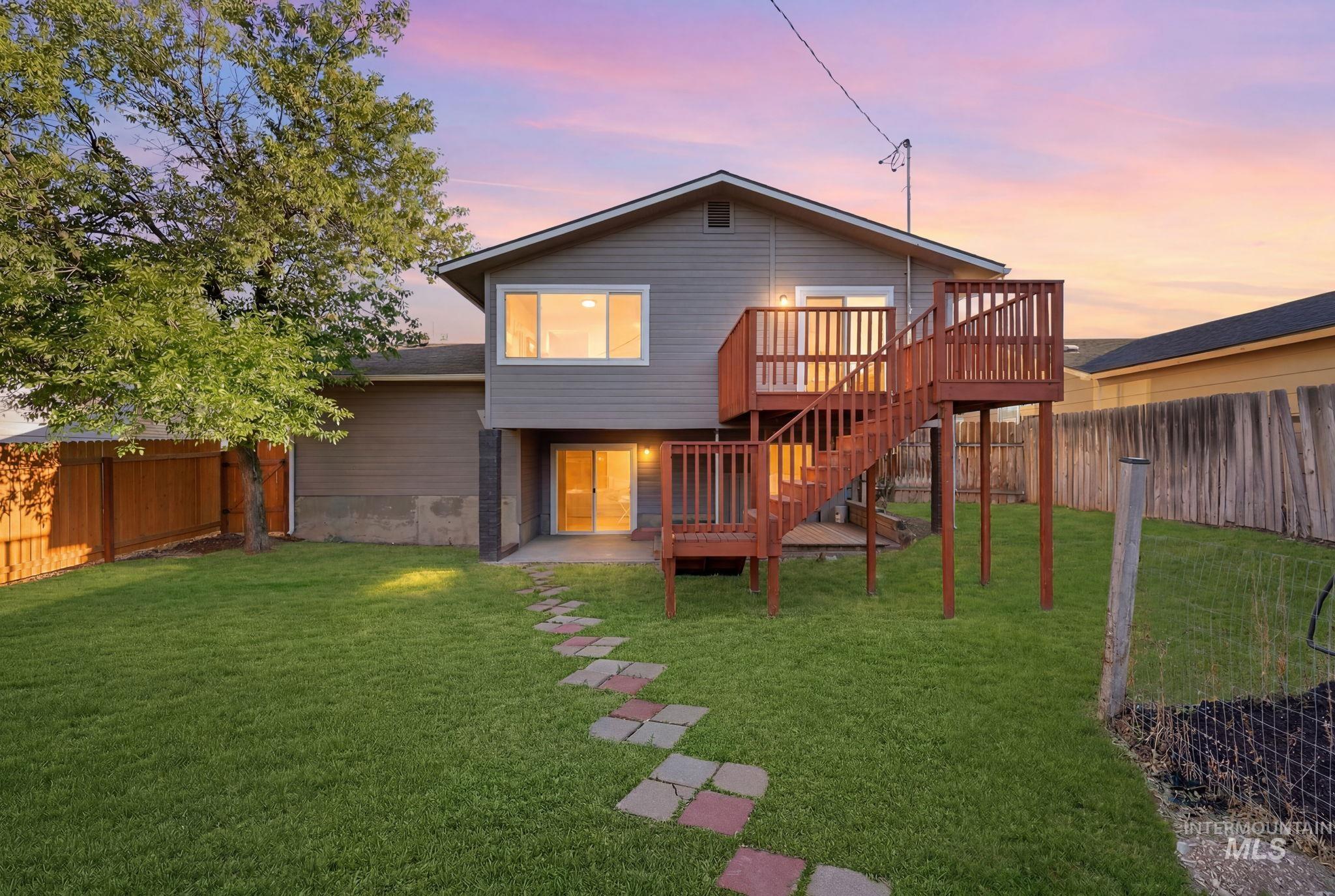 1990 Panama Street Boise, ID 83705 - Photo 46 of 50 Spacious backyard featuring a two-story wood deck with railing, a stone pathway, and a large mature tree