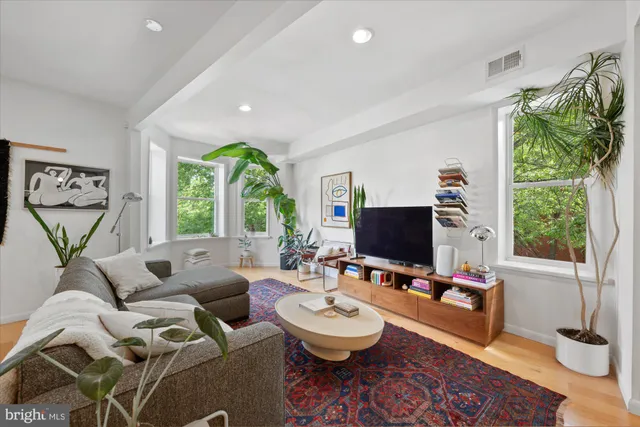 a living room with furniture a window and a flat screen tv