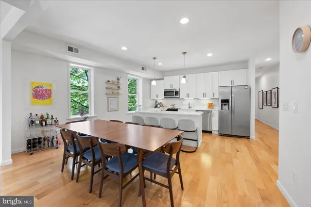 a large kitchen with dining room and wooden floor