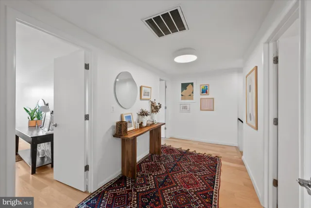 a view of a hallway to a livingroom and a dining room with wooden floor