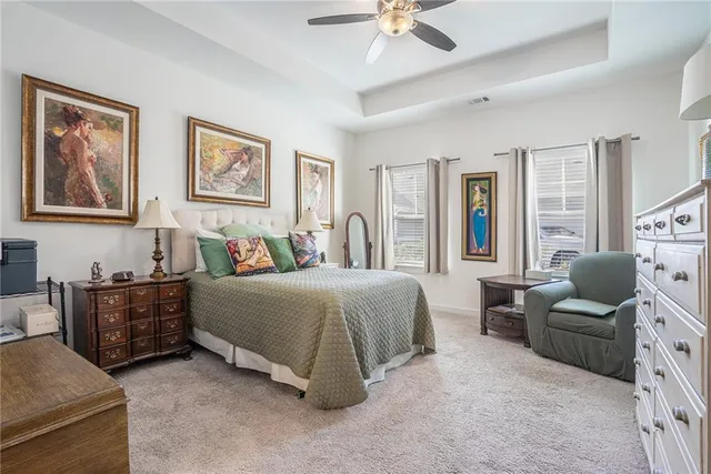 a spacious bedroom with a bed and ceiling fan