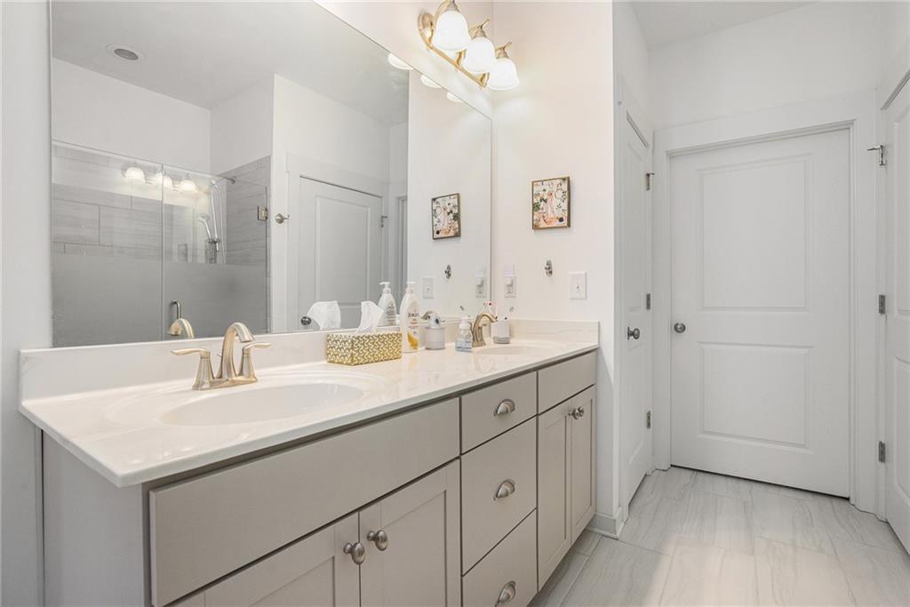 2473 Rathburn Circle Loganville, GA 30052 - Photo 20 of 32 a bathroom with a sink double vanity and a mirror