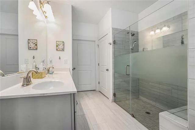 a bathroom with a sink shower and a mirror