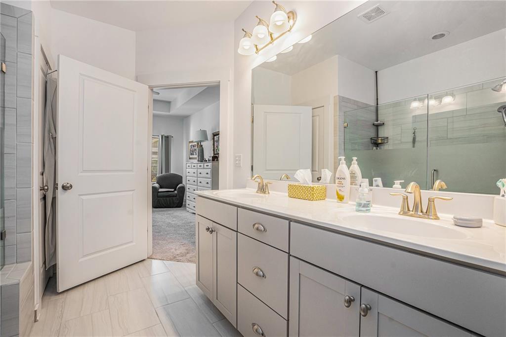 2473 Rathburn Circle Loganville, GA 30052 - Photo 22 of 32 a spacious bathroom with a double vanity sink mirror and shower