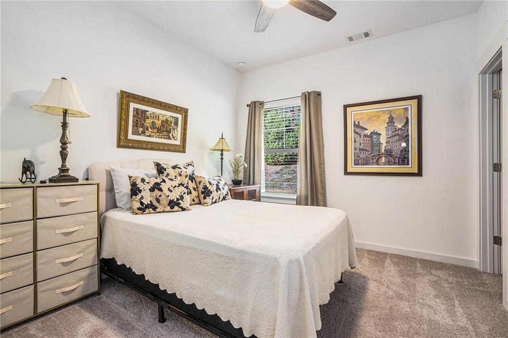 2473 Rathburn Circle Loganville, GA 30052 - Photo 24 of 32 a bedroom with a bed and a night stand