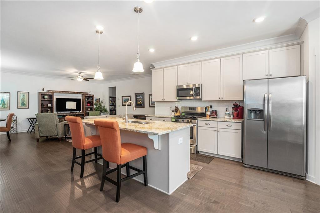 2473 Rathburn Circle Loganville, GA 30052 - Photo 3 of 32 a kitchen with refrigerator a sink and chairs