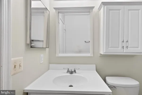 a bathroom with a sink a toilet and mirror