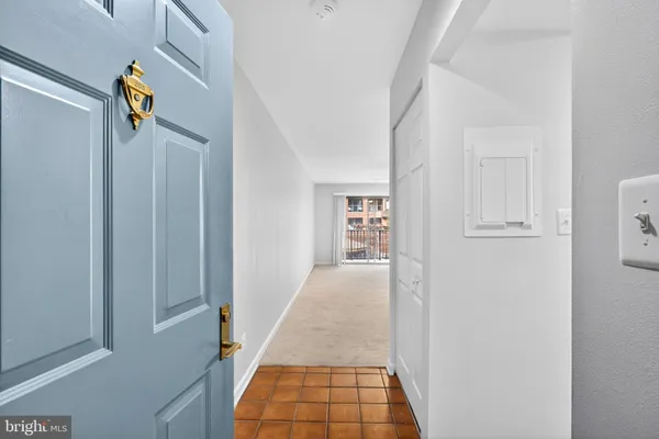 a view of a hallway with white cabinets and wooden floor