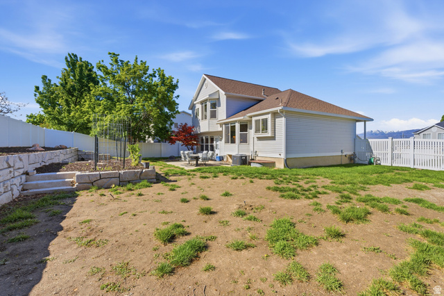 11189 Ohenry Road East Sandy, UT 84070 - Photo 32 of 44 Expansive rear yard featuring a tiered retaining wall, concrete steps, and a dedicated garden area