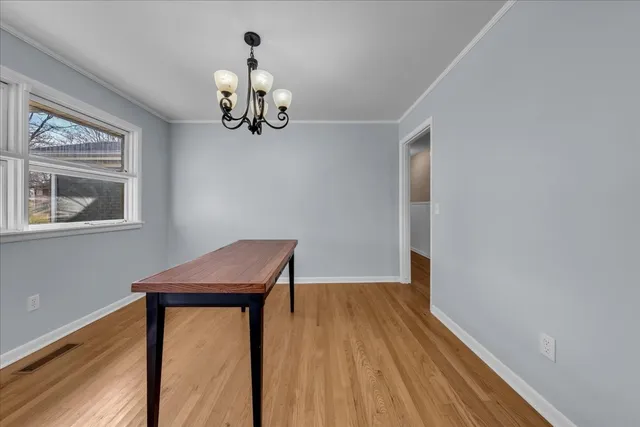 a view of a room with wooden floor chandeliers and staircase
