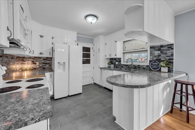 a kitchen with stainless steel appliances granite countertop a sink a stove and a refrigerator