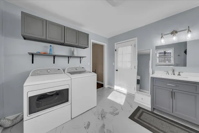 a utility room with sink dryer and washer
