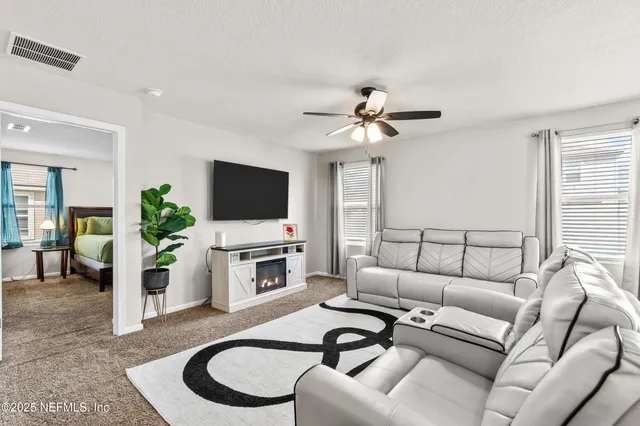 a living room with furniture flat screen tv and a large window