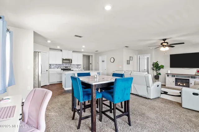 a view of a dining room with furniture and a kitchen