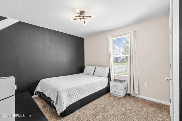 a bedroom with a bed and a window