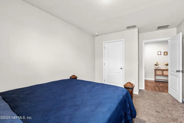 a bed room with a bed and a view of kitchen