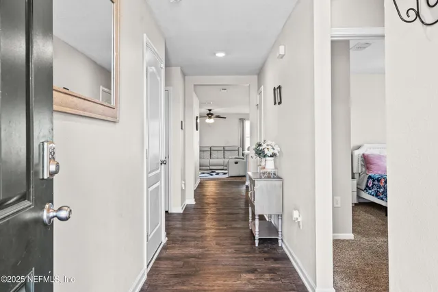 a view of a hallway with a livingroom and a chandelier