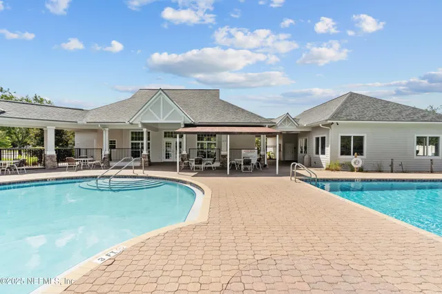 a patio with a table and chairs under an umbrella