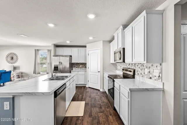 a kitchen with stainless steel appliances a sink stove and refrigerator