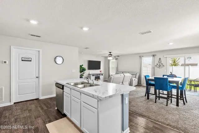 a living room with furniture a dining table and chairs with wooden floor