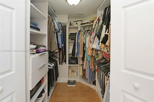 a view of walk in closet with clothes and shoes