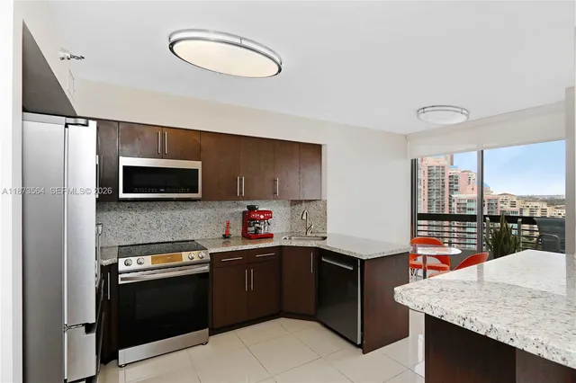 a kitchen with stainless steel appliances granite countertop a sink dishwasher stove and refrigerator