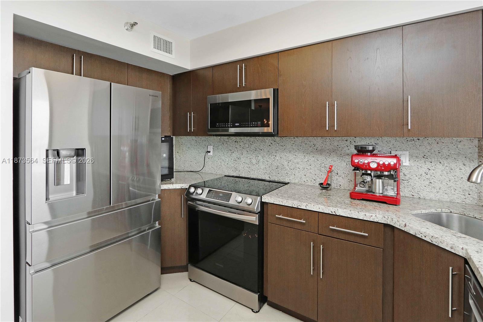 3530 Mystic Pointe Drive, Unit 2402 Aventura, FL 33180 - Photo 23 of 31 a kitchen with a refrigerator stove and microwave
