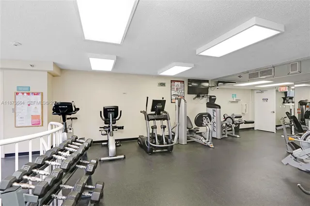 a room with gym equipment and large mirror