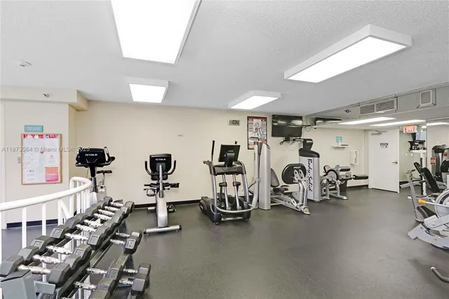 a room with gym equipment and large mirror