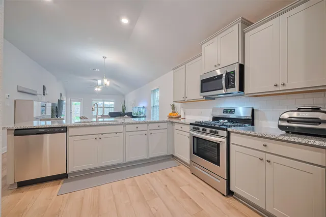 a kitchen with granite countertop white cabinets and white appliances