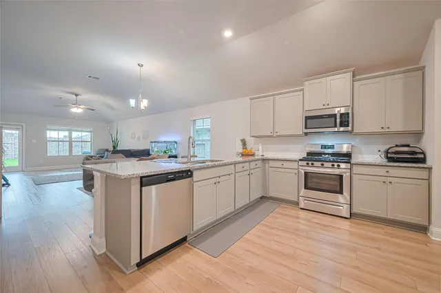a kitchen with granite countertop white cabinets and white appliances