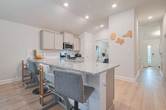 a kitchen with a sink a microwave a refrigerator and cabinets